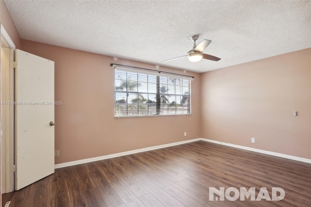 empty room with ceiling fan, baseboards, dark wood finished floors, and a textured ceiling