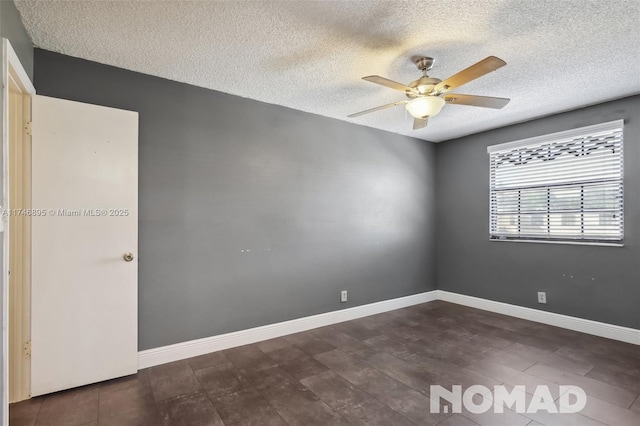 unfurnished room featuring a ceiling fan, dark wood finished floors, a textured ceiling, and baseboards