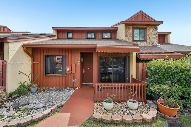 view of front of property featuring stone siding, a porch, and a shingled roof