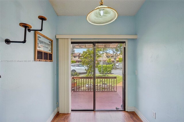 entryway with wood finished floors and baseboards