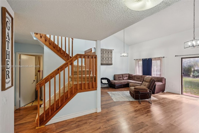 living room featuring stairs, a notable chandelier, and wood finished floors