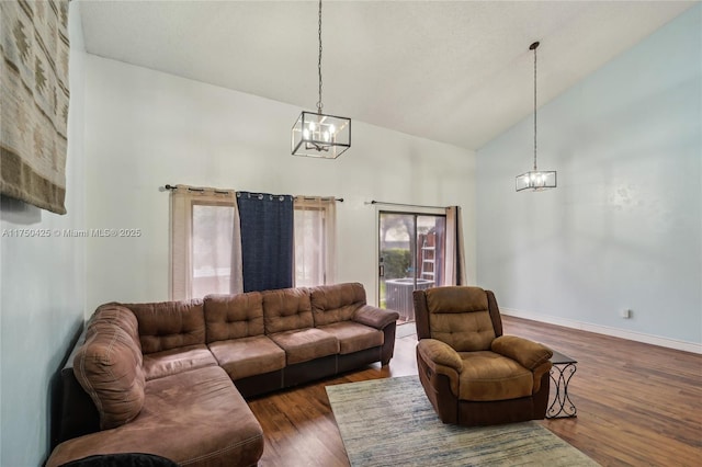 living room featuring baseboards, high vaulted ceiling, wood finished floors, and a notable chandelier