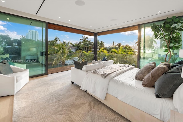 bedroom featuring a wall of windows, light wood-type flooring, and access to exterior