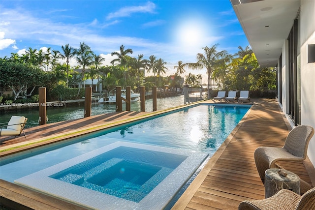 view of swimming pool with a water view and a pool with connected hot tub