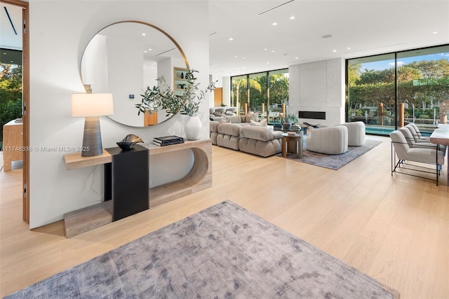 living room with light wood-style floors, expansive windows, and recessed lighting