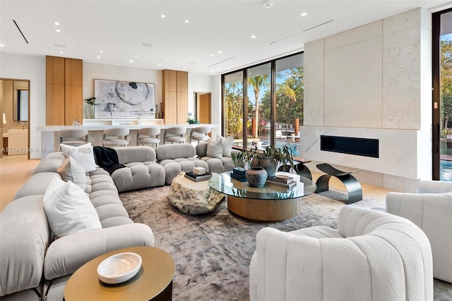 living area featuring light wood-style floors, expansive windows, and recessed lighting