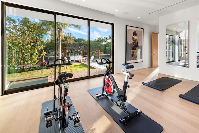 workout room with light wood-type flooring and recessed lighting