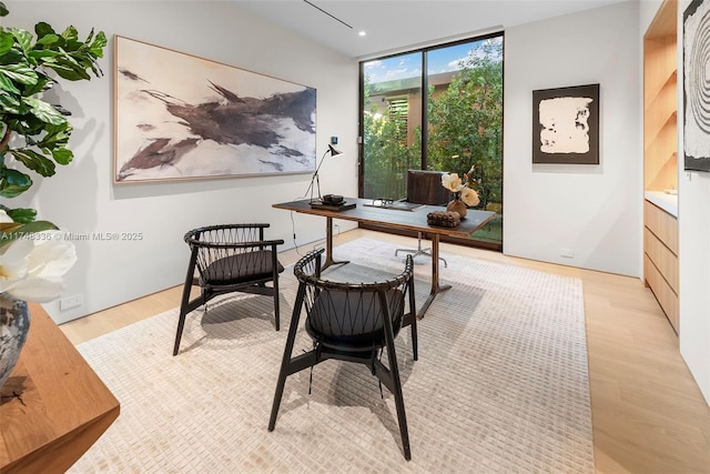 office area featuring floor to ceiling windows and light wood-style flooring