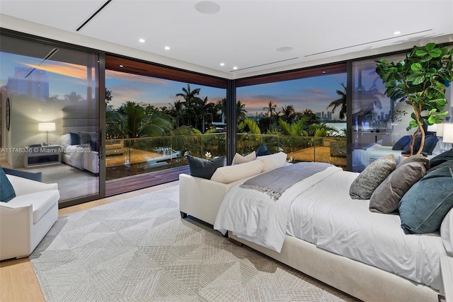 bedroom featuring expansive windows, recessed lighting, light wood-type flooring, and access to exterior