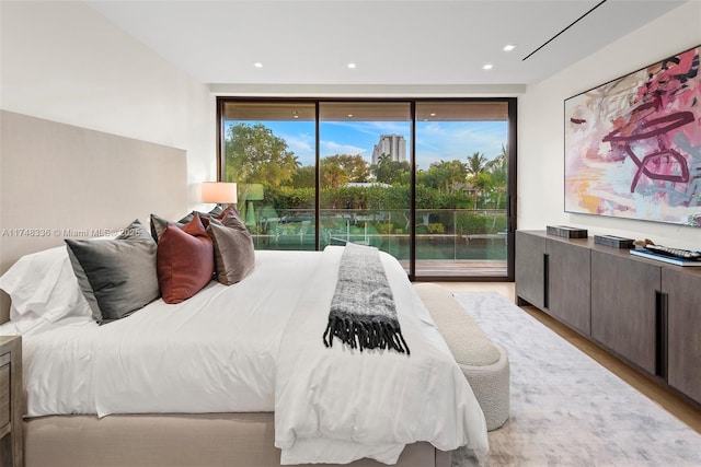 bedroom with access to outside, floor to ceiling windows, light wood-style flooring, and recessed lighting