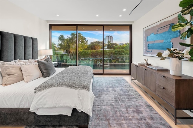 bedroom featuring light wood finished floors, access to outside, floor to ceiling windows, and recessed lighting