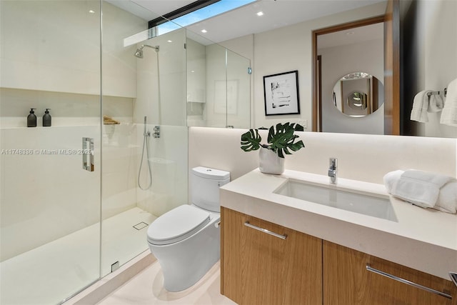 bathroom with a shower stall, toilet, and vanity