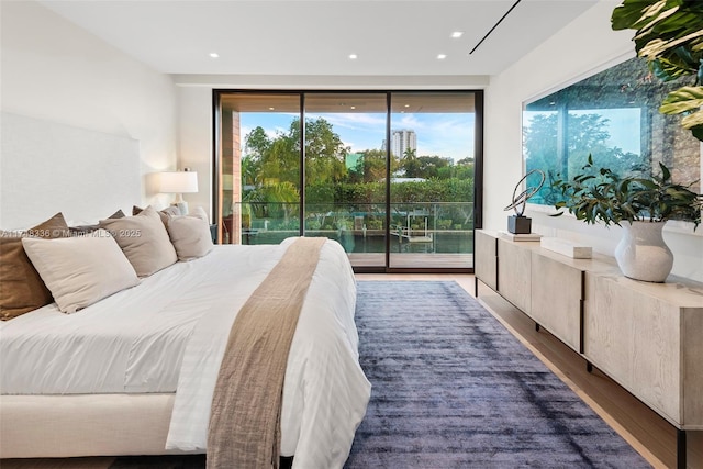 bedroom featuring recessed lighting, dark wood finished floors, and access to exterior