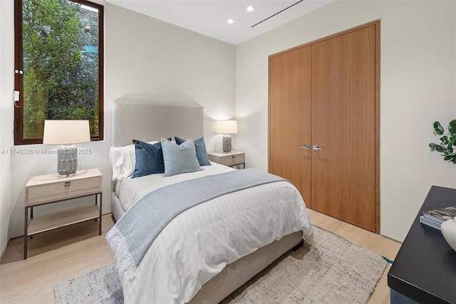 bedroom with a closet, light wood-type flooring, and recessed lighting