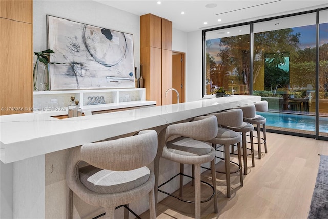 bar featuring light wood-style flooring, floor to ceiling windows, and recessed lighting