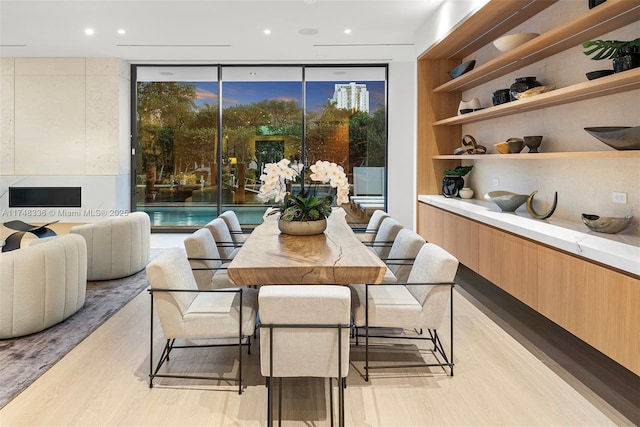 dining space featuring built in features, expansive windows, light wood finished floors, and recessed lighting