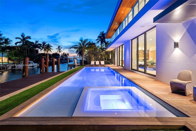 pool with a water view and an in ground hot tub