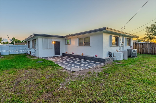 back of house featuring a yard, a fenced backyard, a patio, and cooling unit