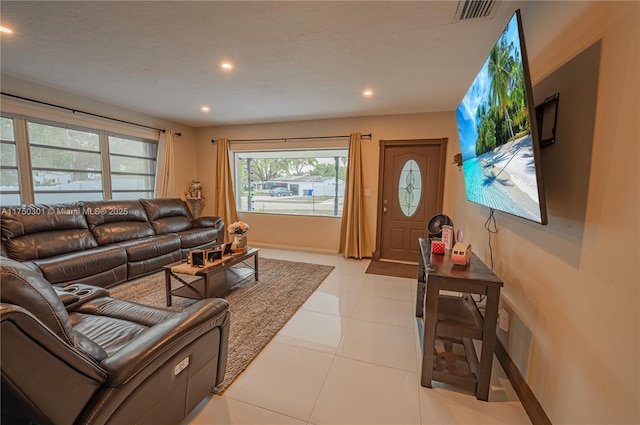 living area featuring recessed lighting, visible vents, a textured ceiling, and light tile patterned floors