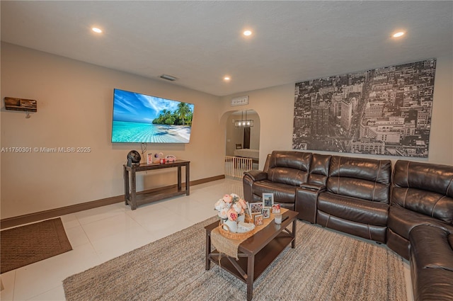 tiled living area featuring arched walkways, baseboards, visible vents, and recessed lighting