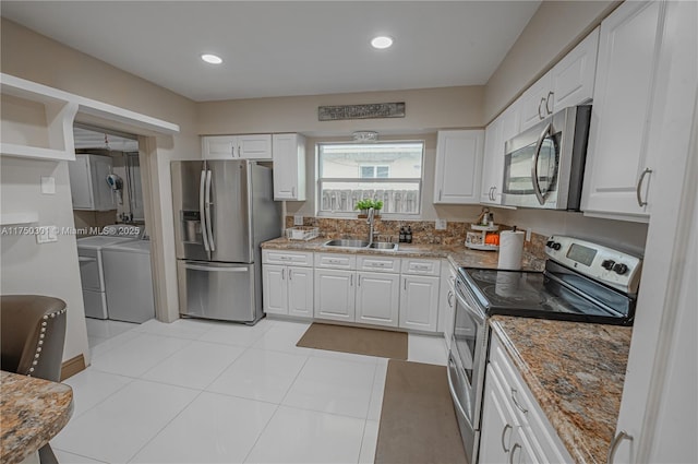 kitchen with washing machine and clothes dryer, stainless steel appliances, white cabinetry, open shelves, and a sink