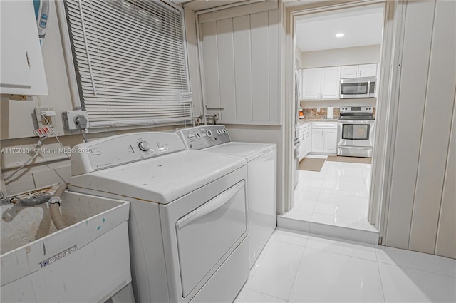 laundry room with laundry area, light tile patterned floors, a sink, and washing machine and clothes dryer