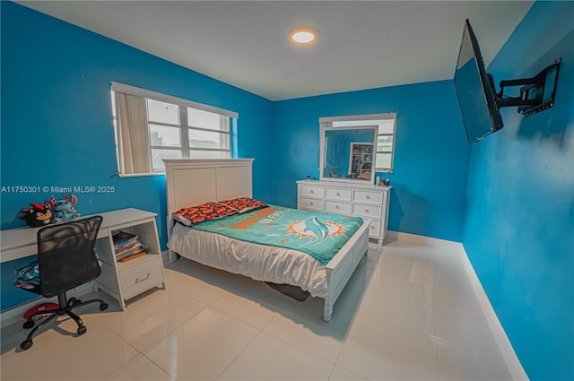 bedroom with light tile patterned flooring and baseboards