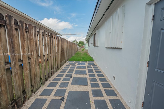 view of side of property featuring fence and stucco siding