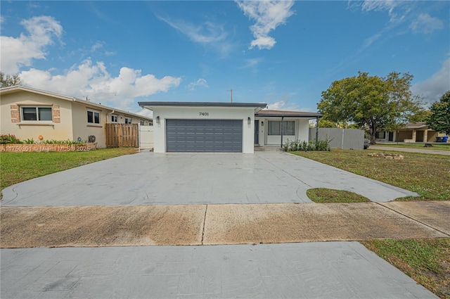 ranch-style home with an attached garage, fence, concrete driveway, and a front yard