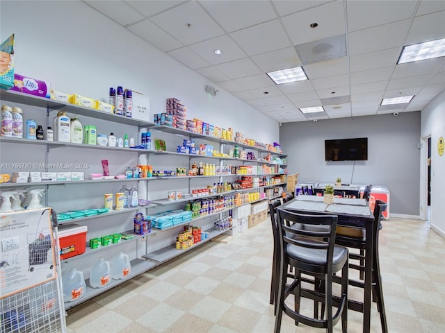 playroom featuring light floors, baseboards, and a drop ceiling