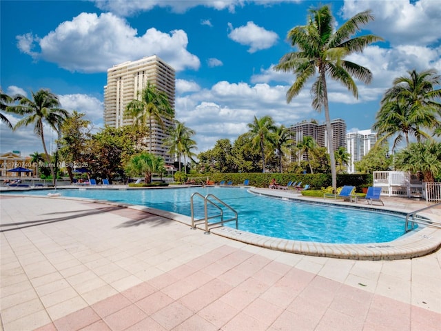 community pool with a view of city and a patio area