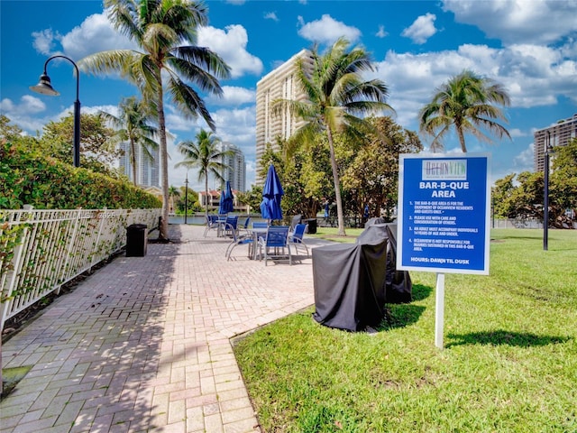 surrounding community featuring a lawn, a patio area, and fence