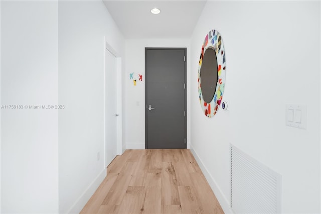 corridor featuring light wood-type flooring, visible vents, baseboards, and recessed lighting