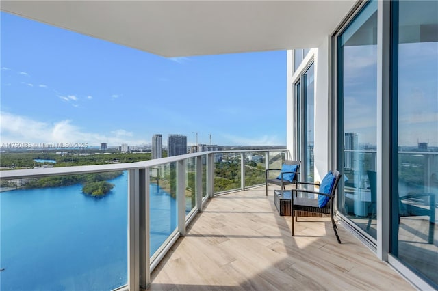 balcony featuring a water view and a city view