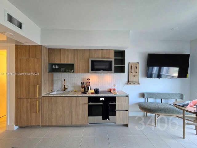 kitchen with visible vents, modern cabinets, oven, and built in microwave