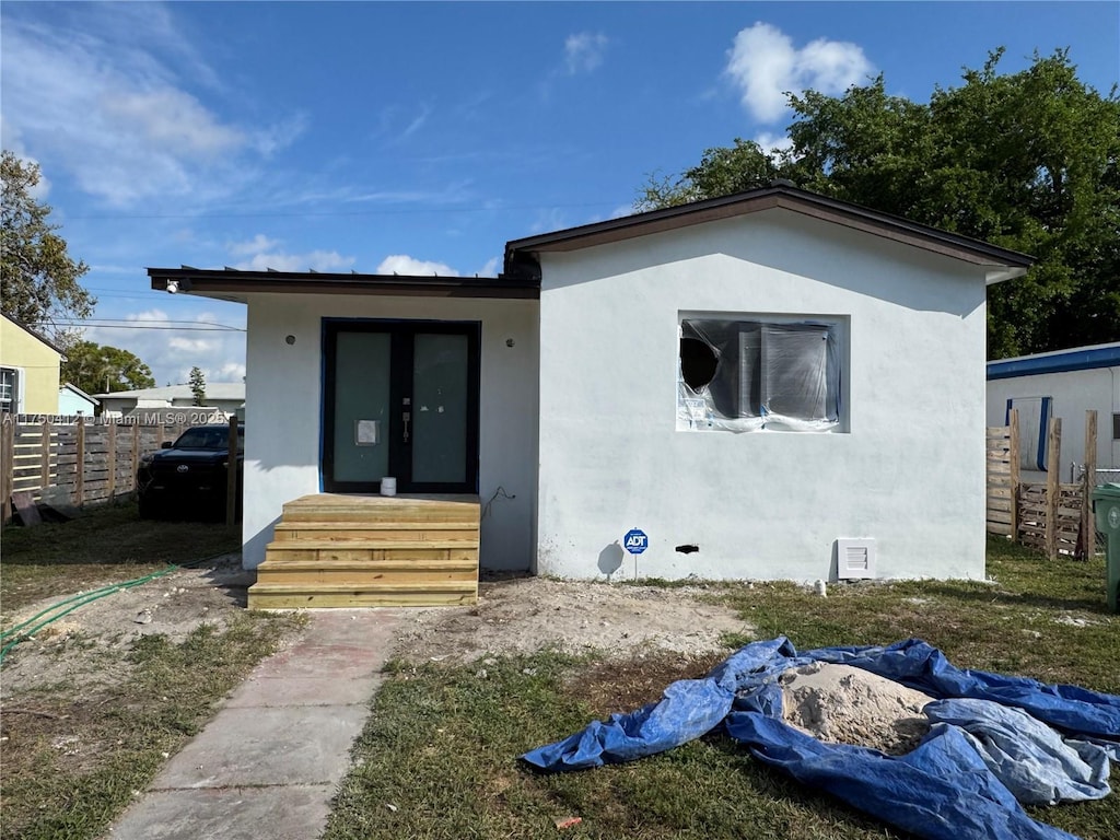 view of front facade featuring fence and stucco siding