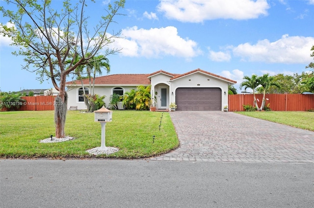 mediterranean / spanish-style house featuring a tiled roof, an attached garage, fence, decorative driveway, and a front lawn