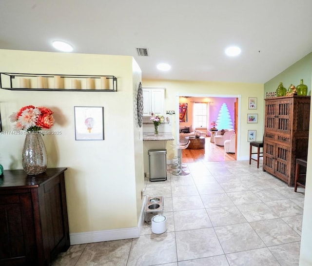 corridor featuring recessed lighting, light tile patterned flooring, visible vents, and baseboards