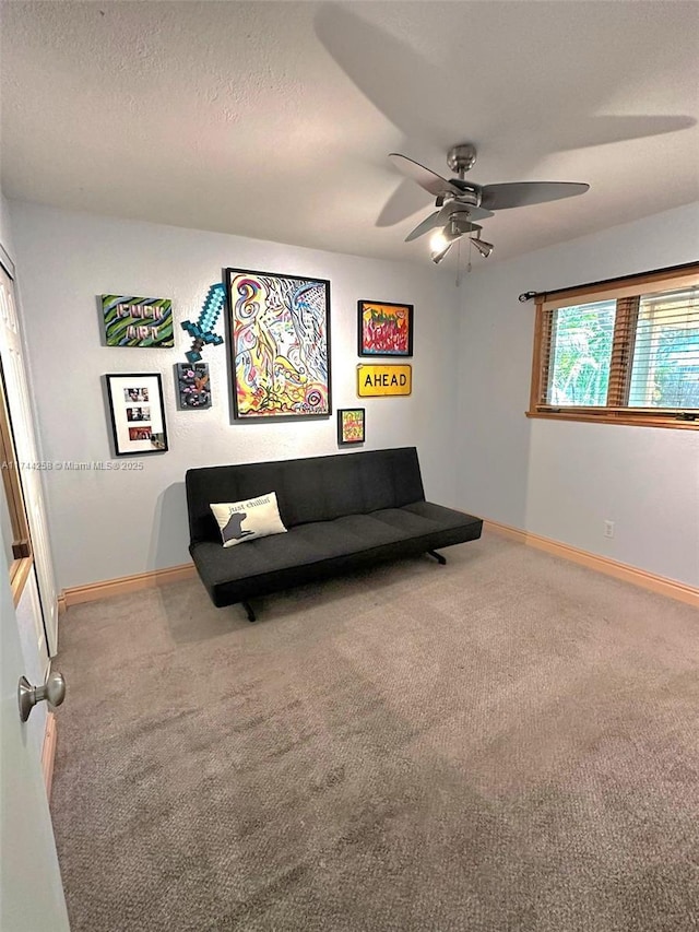 living area with carpet floors, a ceiling fan, baseboards, and a textured ceiling