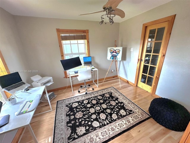 office featuring light wood-type flooring, ceiling fan, and baseboards