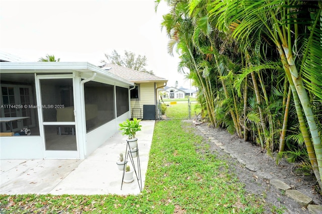 view of yard with a sunroom, fence, and a gate