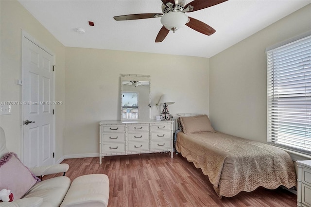 bedroom featuring multiple windows, light wood-style flooring, and a ceiling fan