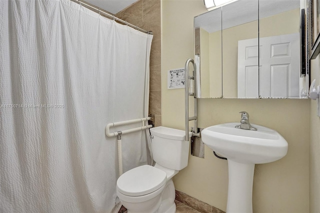 bathroom featuring curtained shower and toilet