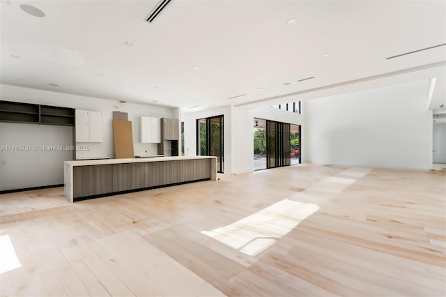 unfurnished living room featuring light wood finished floors and visible vents