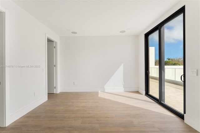 unfurnished room featuring light wood-style floors and baseboards