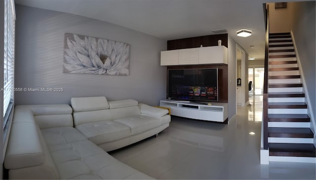 living room featuring visible vents and stairs