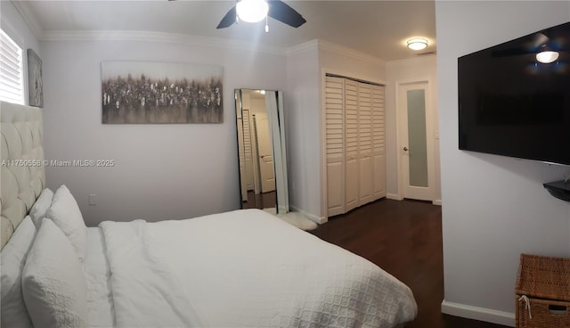 bedroom featuring dark wood-style flooring, a ceiling fan, baseboards, ornamental molding, and a closet