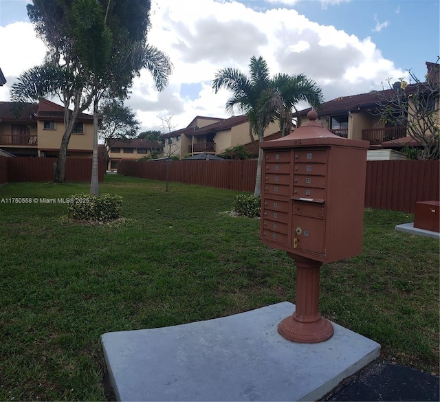 view of yard with fence and mail area