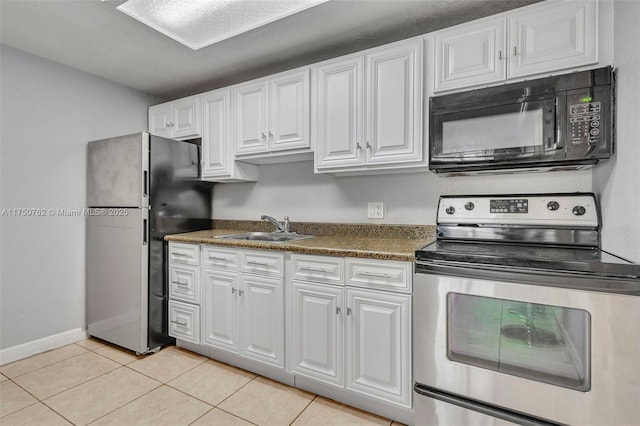 kitchen featuring appliances with stainless steel finishes, white cabinetry, a sink, and light tile patterned floors