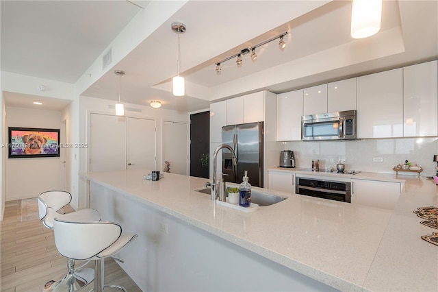 kitchen featuring visible vents, white cabinets, appliances with stainless steel finishes, modern cabinets, and decorative light fixtures